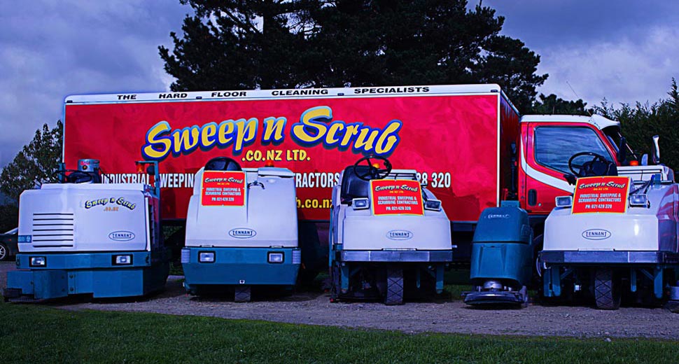 Ride-on and walk-behind scrubbers in front of the Sweep n Scrub truck